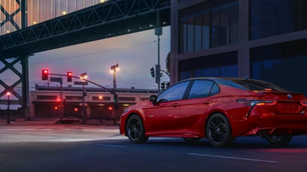 Lateral do Toyota Camry 2022 vermelho andando na estrada de noite
