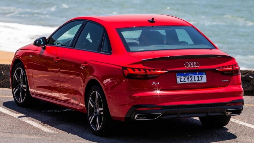 Audi A4 2022 vermelho traseira, estacionado na beira da praia