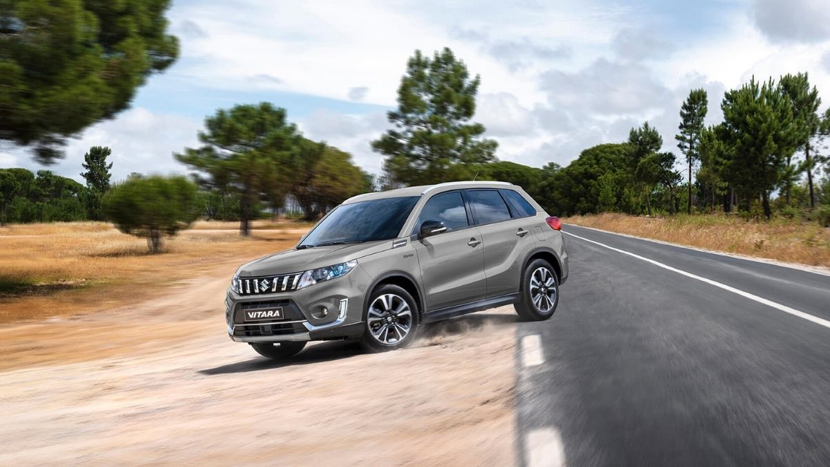 Suzuki Vitara 2022 marrom saindo do asfalto e indo pra estrada de chão
