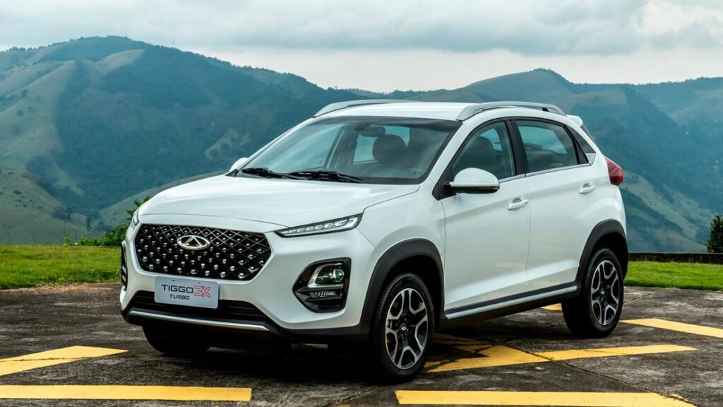 Caoa Chery Tiggo 3X branco estacionada em frente a montanha