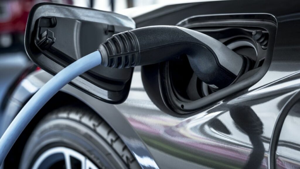Carro elétrico plugado para recarregar a bateria
