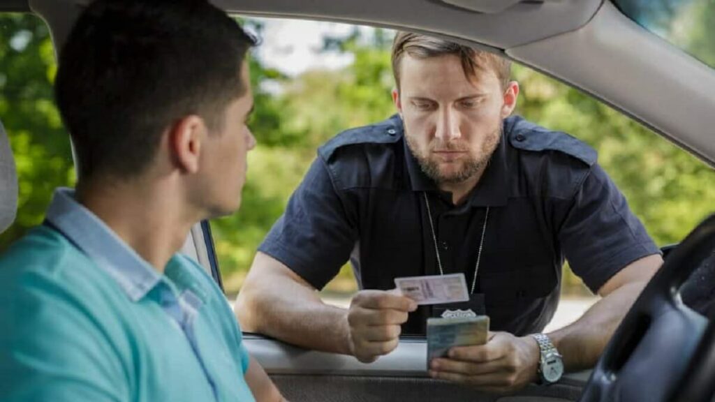 Policial conferindo documento de habilitação