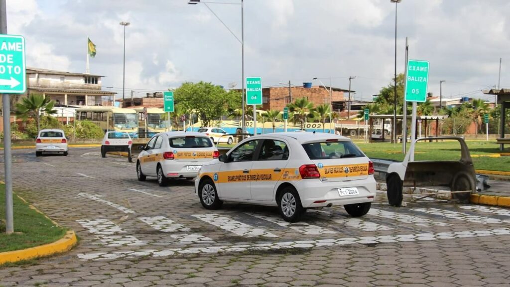 Pessoas dirigindo carros da autoescola, para fazer teste da CNH