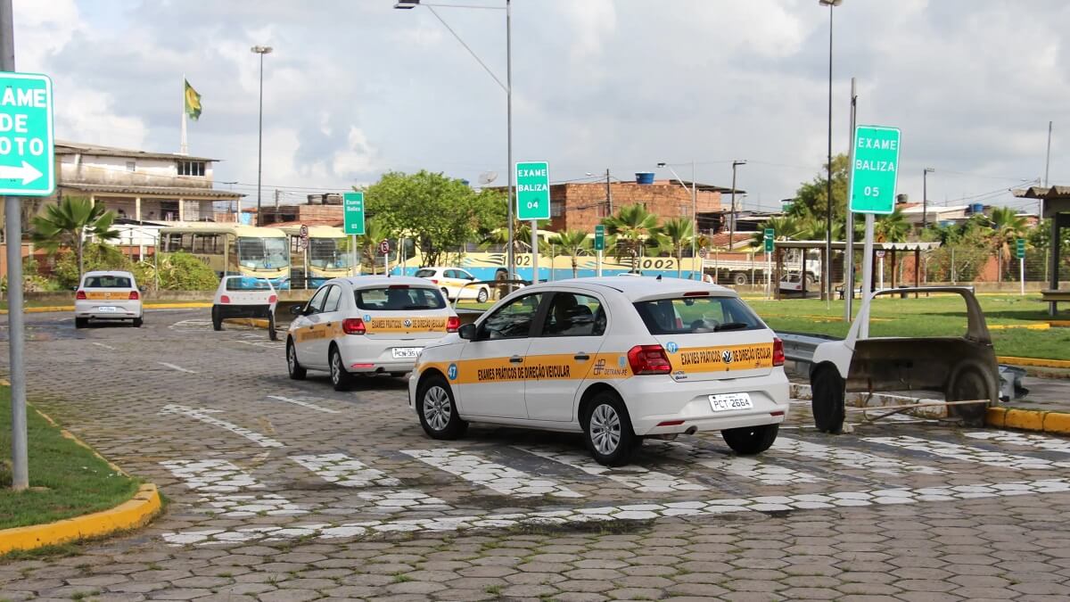 Pessoas dirigindo carros da autoescola, para fazer teste da CNH na autoescola