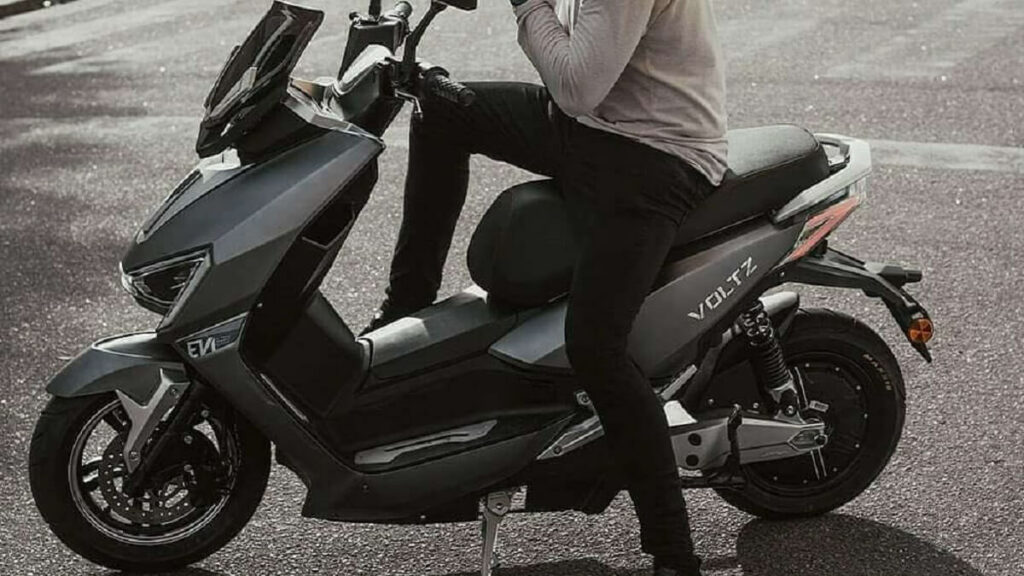 EV1 Sport 2022 na cor cinza, com motociclista montado nela