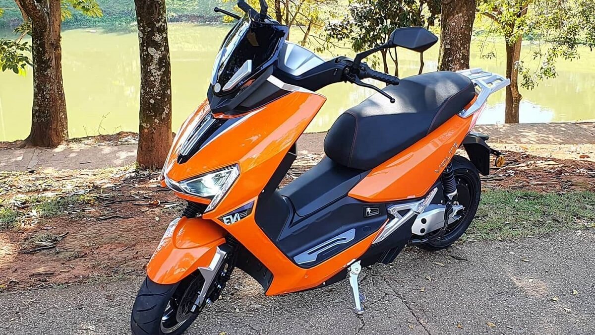 EV1 Sport 2022 na cor laranja, estacionada perto de árvores