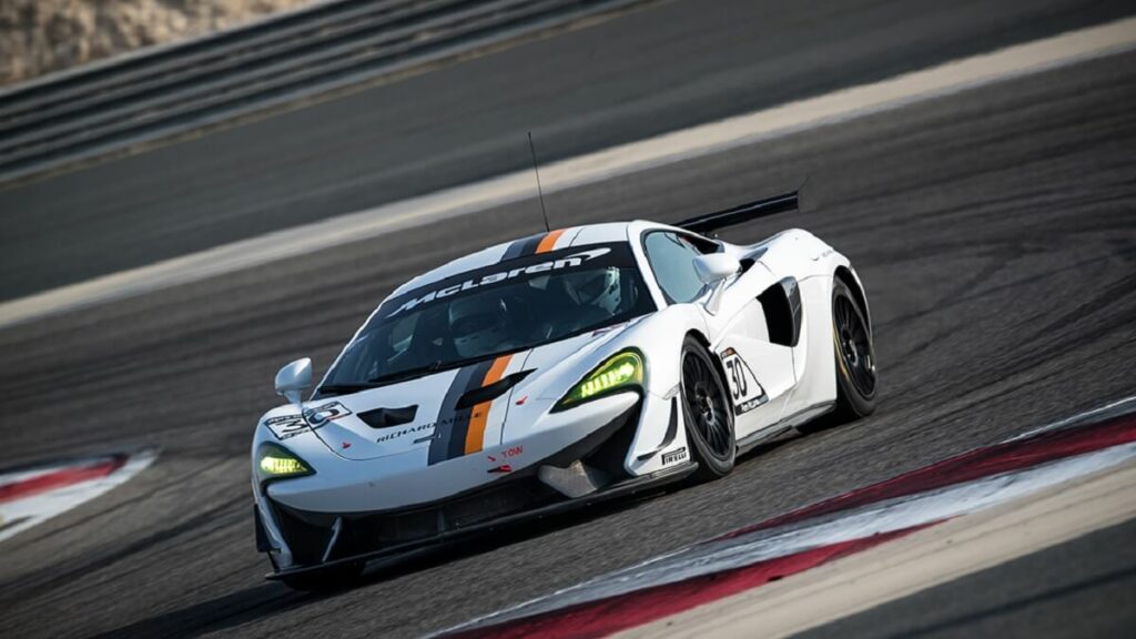 Imagem do jogo Forza Motoresport 4 com um carro branco fazendo drifit em uma pista