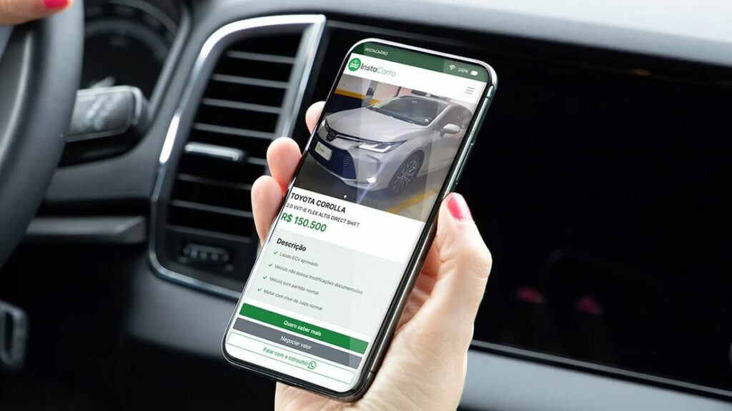 Pessoa dentro do carro segurando celular com app da InstaCarro