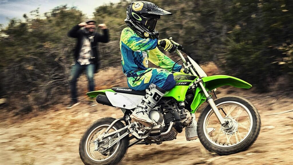 Nova Kawasaki KLX 110 2022 andando na terra, moto da cor verde