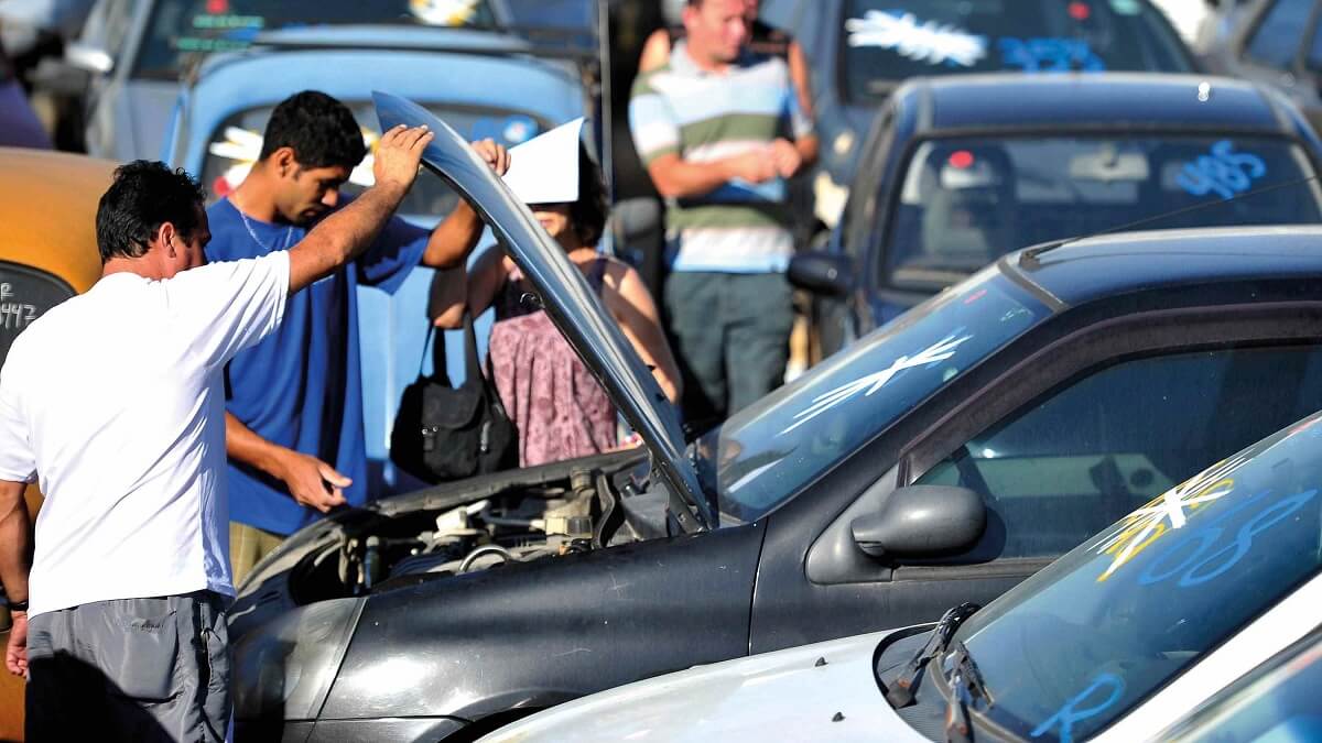 Pessoas olhando motor do carro no leilão