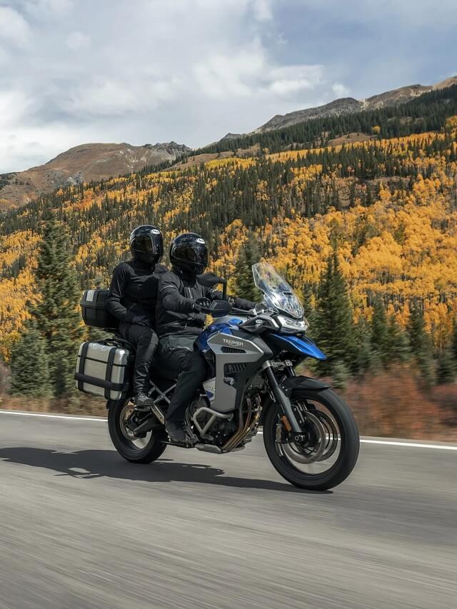 Moto andando na estrada com passageiro, com montanhas de fundo