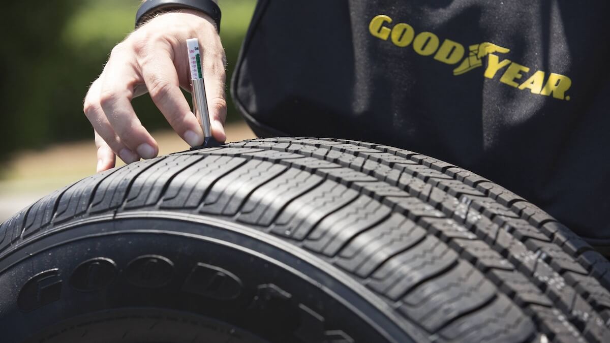 Pneu da Goodyear, e pessoa mexendo no pneu