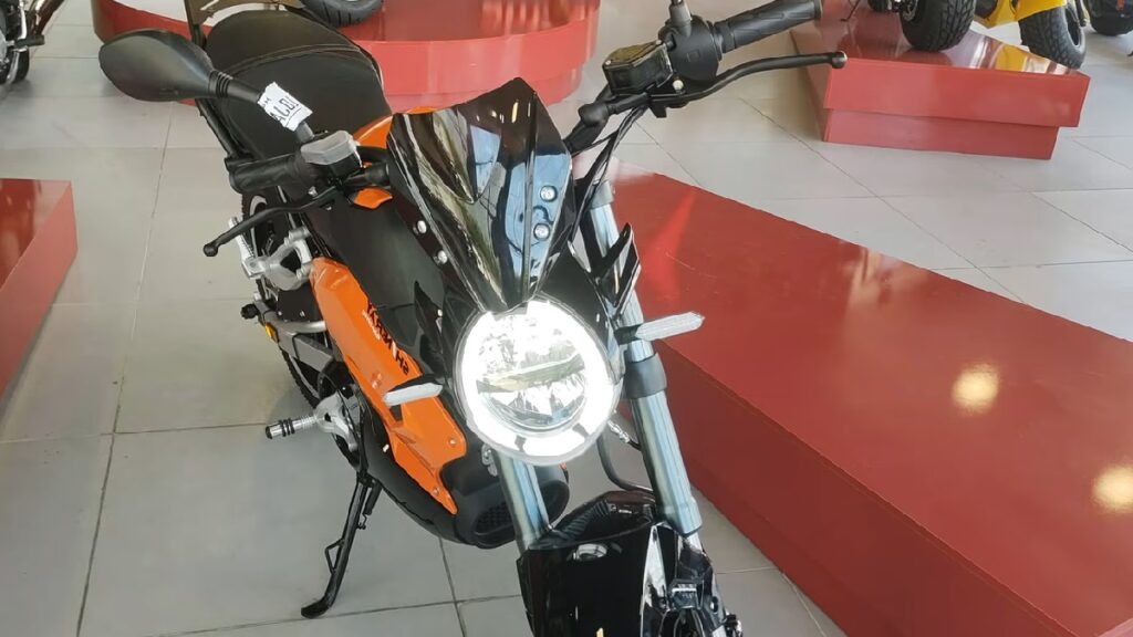 SHE-S 2022 laranja em uma concessionaria com os faróis ligados