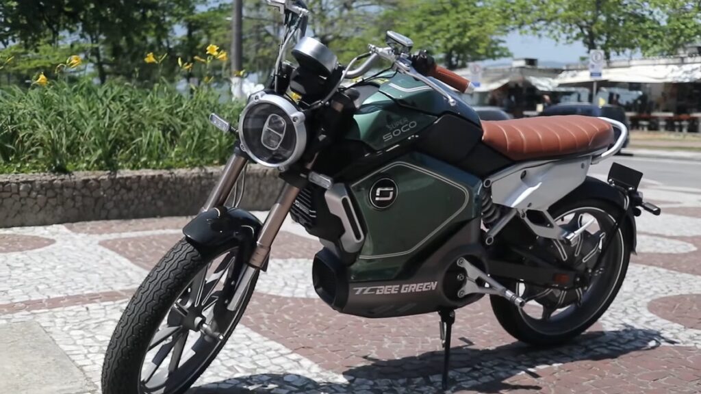 TC 2022 Super Soco verde, com o banco marrom em uma praça.