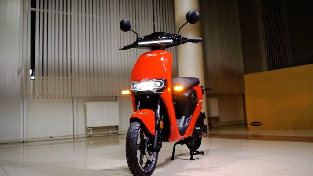 Super Soco CU vermelha com as luzes ligadas dentro de uma garagem