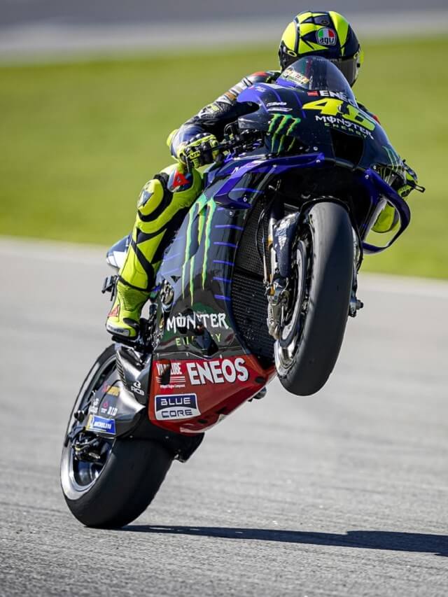 Piloto da MotoGP empinando a moto na pista de corrida