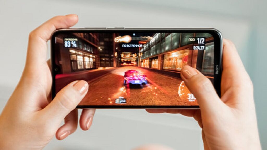 Melhores jogos de corrida para celular com duas mão segurando um celular com um jogo de corrida com um carro azul em um fundo branco