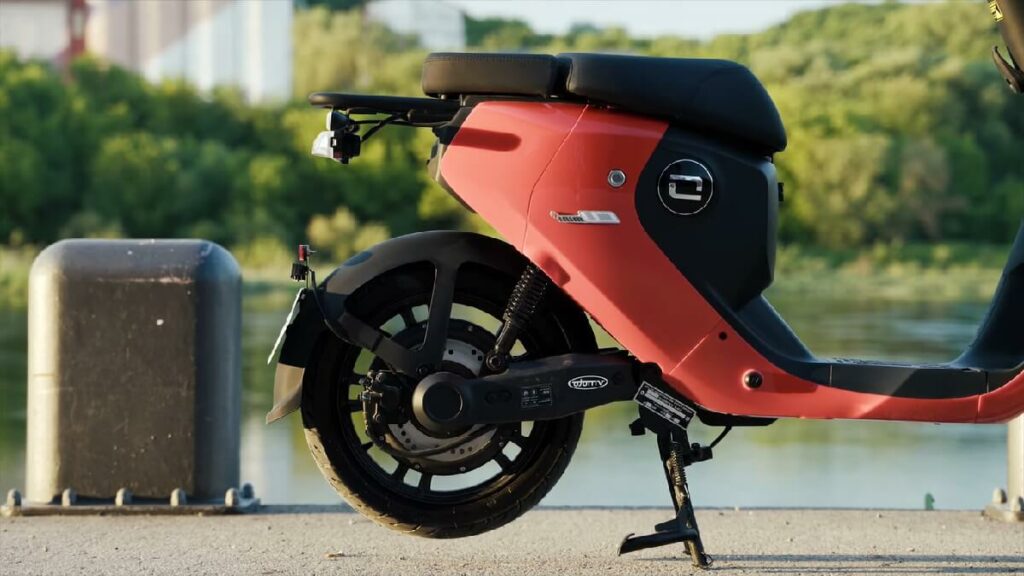 Parte traseira da Super Soco CU 2022 vermelha, com um lago ao fundo