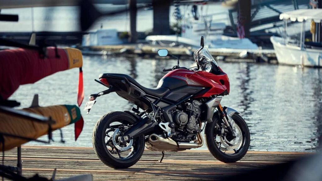 Traseira da nova Tiger Sport 660 2022 na cor vermelham, estacionada perto da água