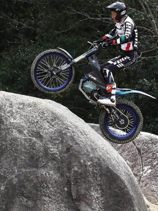 Pessoa andando com a Yamanha TY-E nas pedras