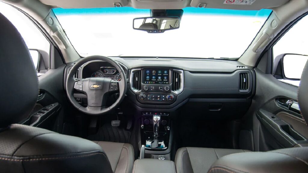 Trailblazer com com interior de cores escuras e muito bem detalhado, com um painel OLE D