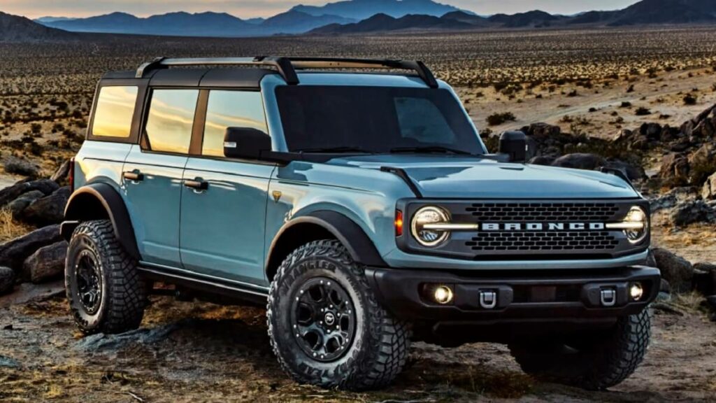 Lateral frontal de uma Ford Bronco 2023  na cor azul claro em um deserto