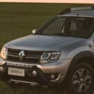 Lateral frontal Oroch 2023 em um campo com um pneu de trator na caçamba.