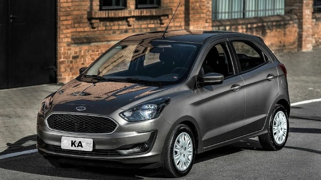 Lateral frontal de uma Ford Ka 2023 na cor preta estacionada na estrada dentro da cidade.