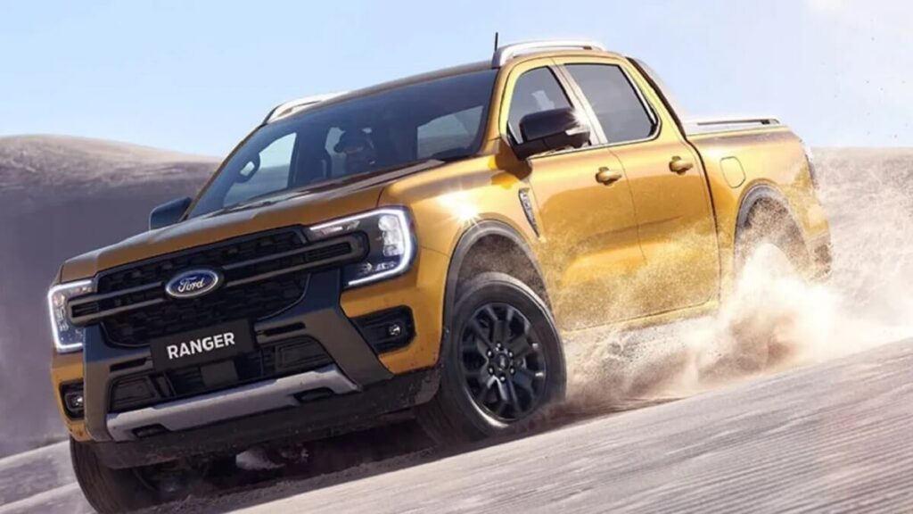 Lateral frontal de uma Ford Ranger 2023 na cor amarela rodando por um deserto
