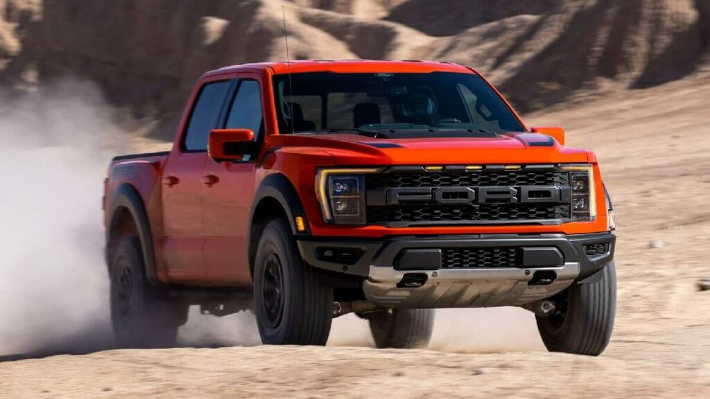 Lateral de uma Ford F-150 2023 na cor vermelha rodando por uma zona montanhosa