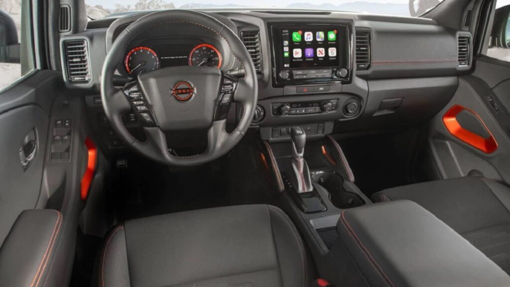 interior Nissan Frontier 2023 com o estofamento preto e tela digital