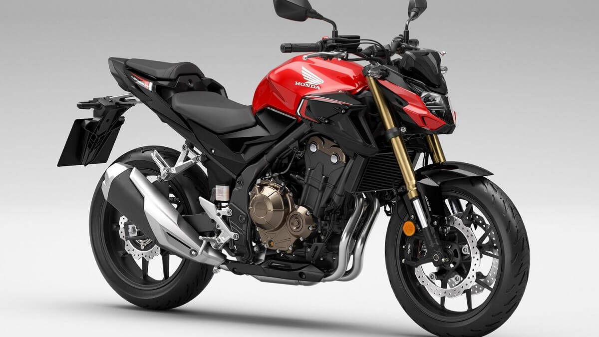 Lateral frontal de uma CB 500F 2023 na cor vermelha, com partes pretas, em um fundo branco.