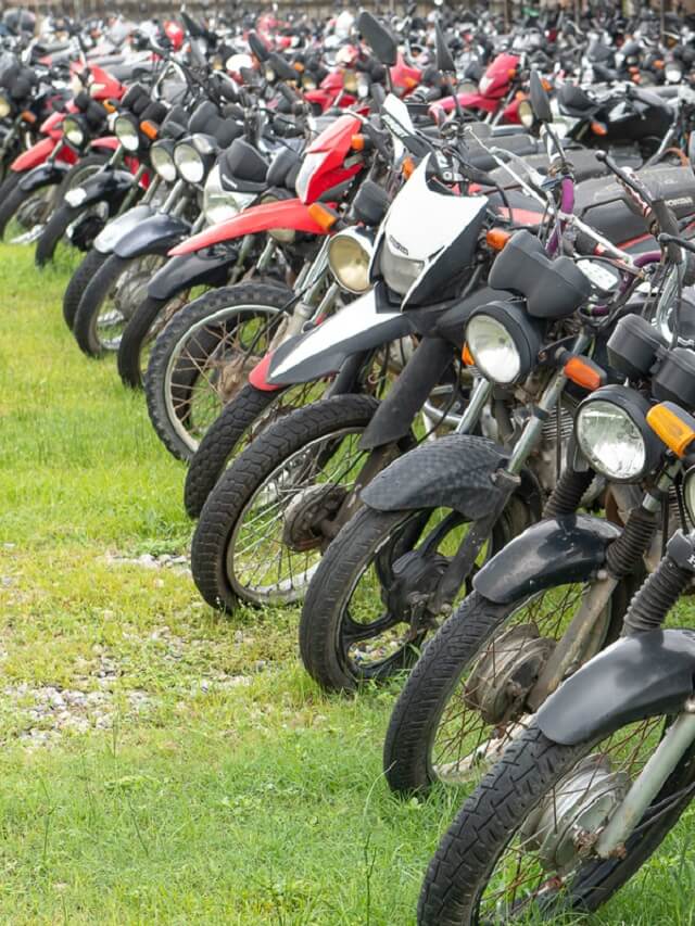 Frente de várias motos de leilão seminovas, estacionadas na grama