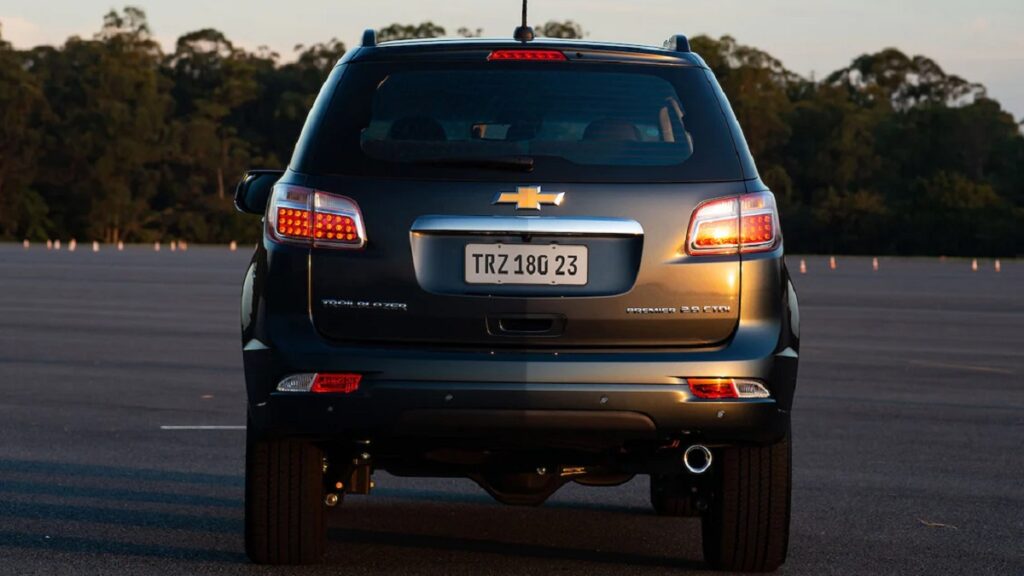 Traseira da Trailblazer cinza, em uma pista de testes com cones ao fundo