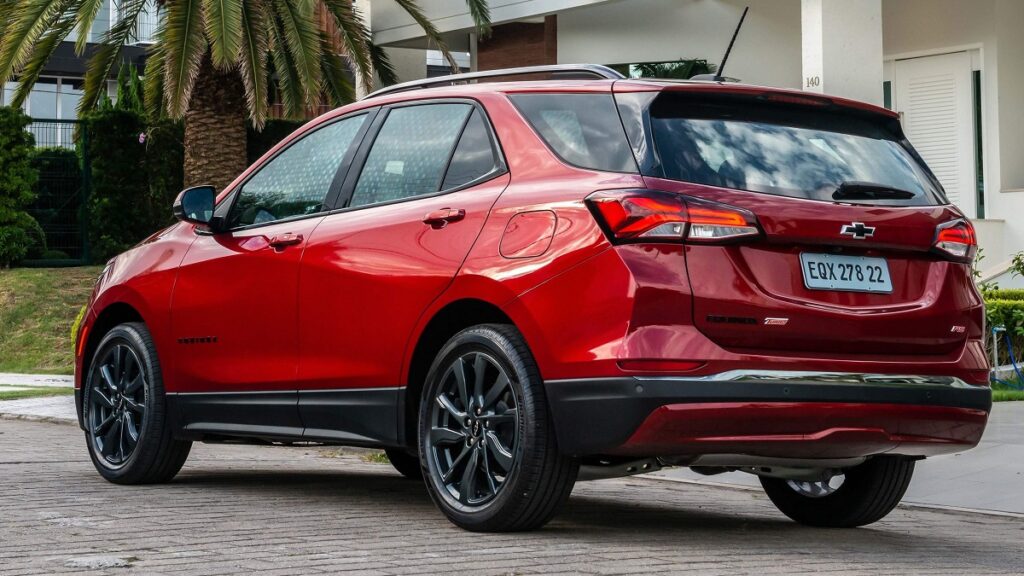 Traseira Chevrolet Equinox RS 2023 vermelha estacionada na frente de uma casa