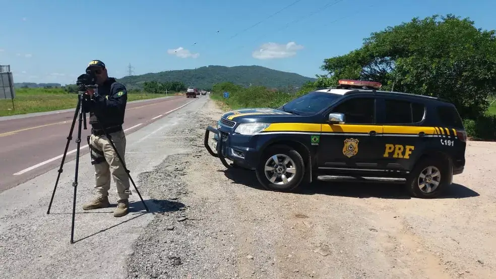 Radar móvel, e carro da policia na rodovia. Com estrada.