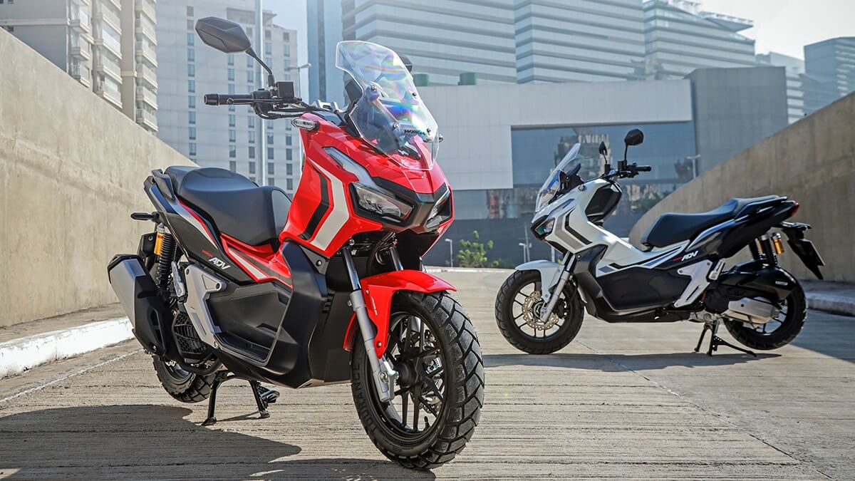Foto de duas ADV 150 2023 a da frente é vermelha e a outra que está atrás é branca