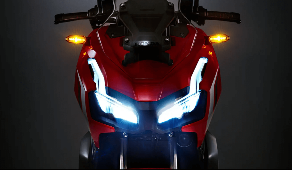 Foto frontal da ADV 150 2023 a imagem mostra o farol com LED