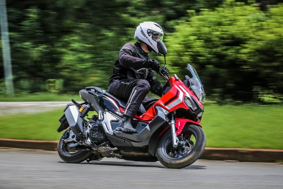 Foto de uma pessoa pilotando uma ADV 150 2023 vermelha