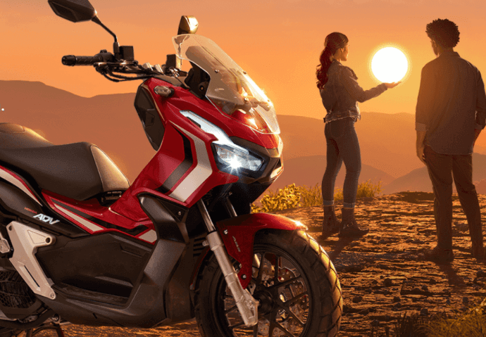 Foto da ADV 150 2023 com um por de sol de fundo e duas pessoas uma no lado da outra
