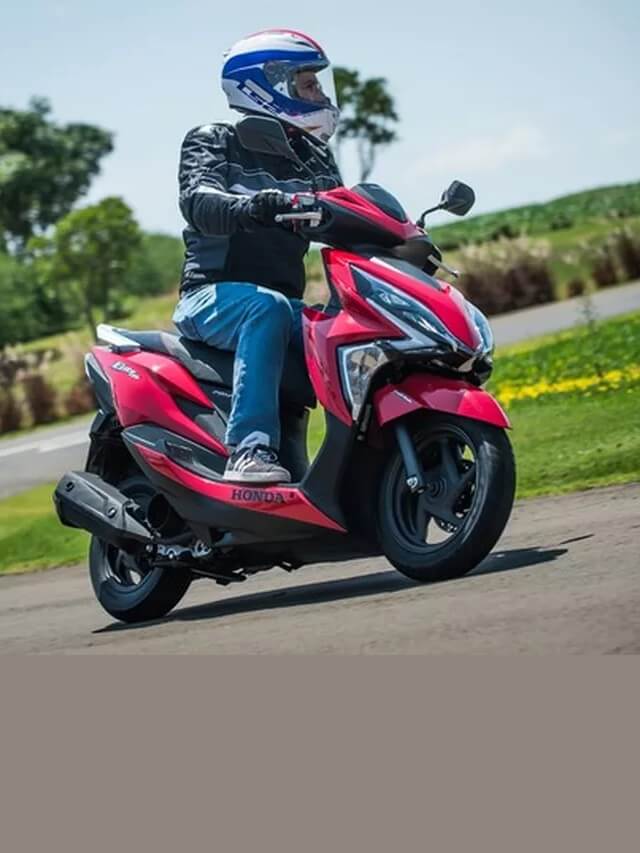Foto de uma pessoa andando com uma Honda Elite 125 2023 vermelha