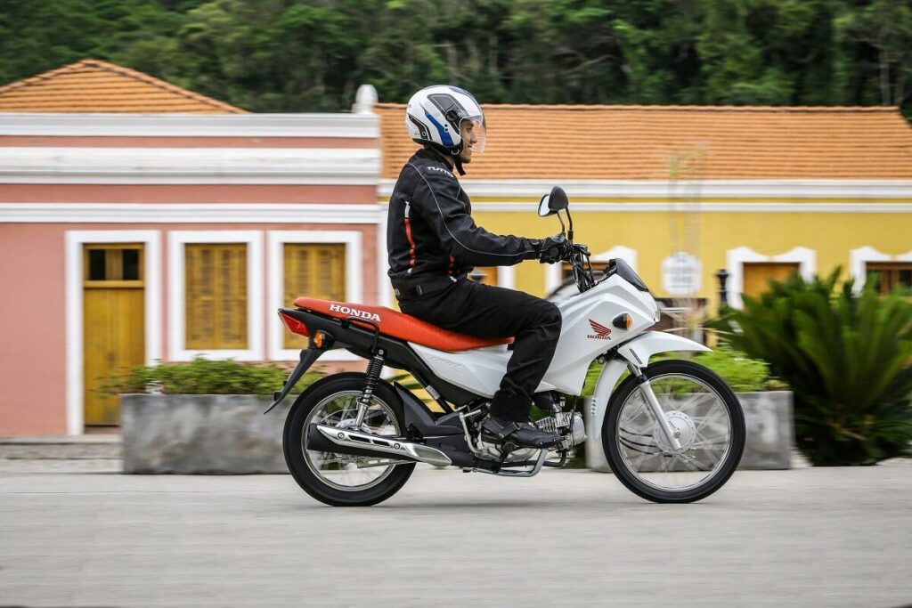Foto de uma pessoa pilotando uma Honda POP 110i 2023 branca