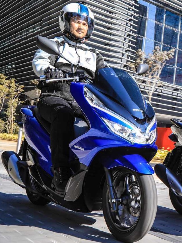 A imagem msotra uma pessoa pilotando uma PCX 2023 na cor azul perolizado.