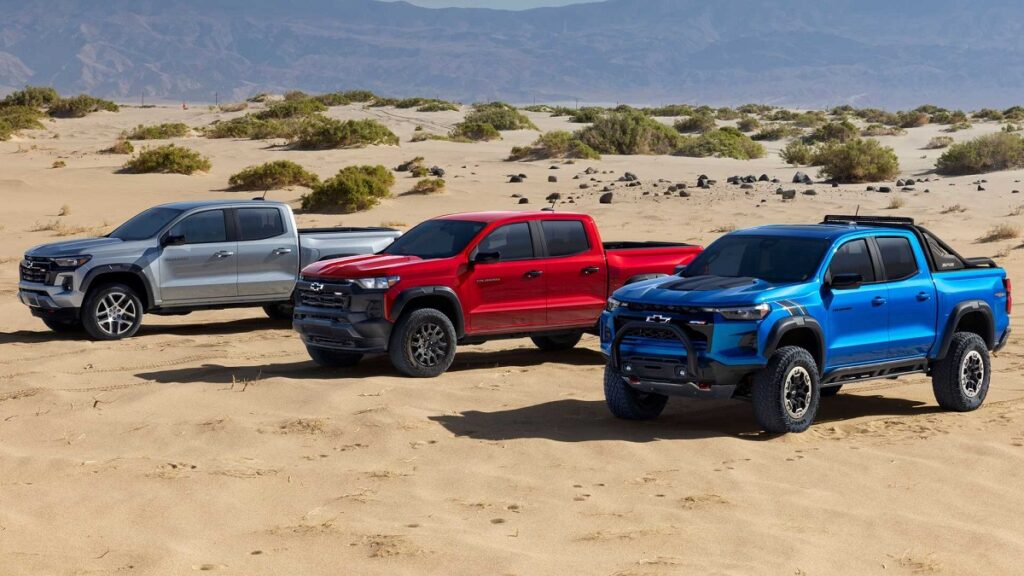 Foto de três Chevrolet Colorado 2023, cada uma representa uma versão, e suas cores são da direita para a esquerda, azul, vermelho e cinza