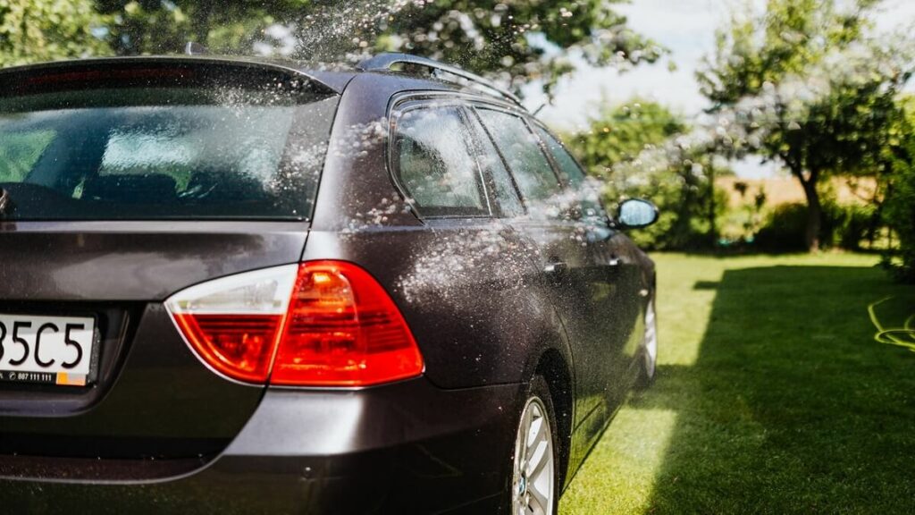 Água sendo jogada em um carro com pintura escura
