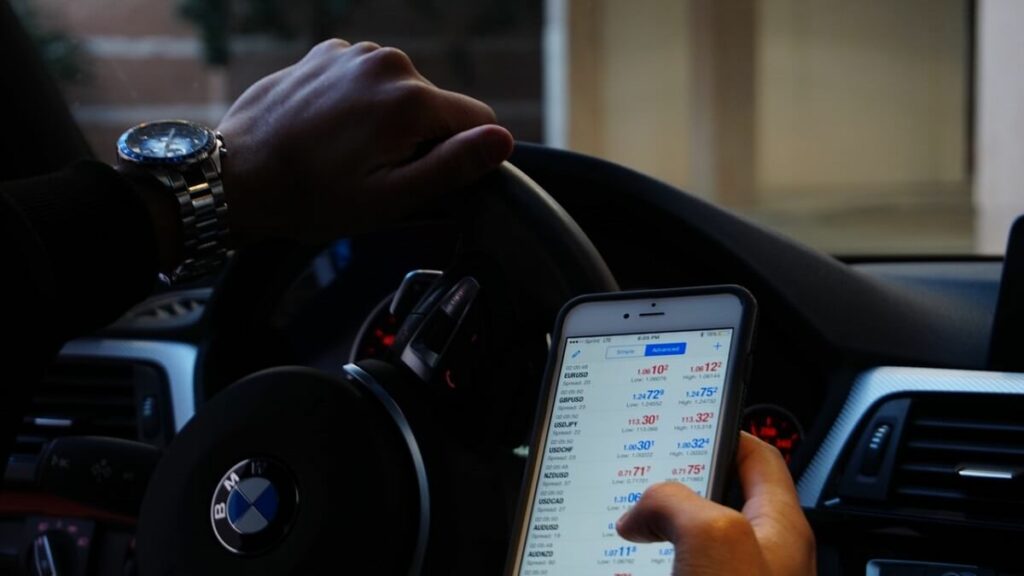 Pessoa usando celular ao conduzir veículo