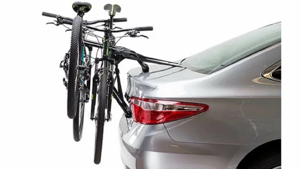 Engate para bicicletas em um carro sedan prata com fundo branco