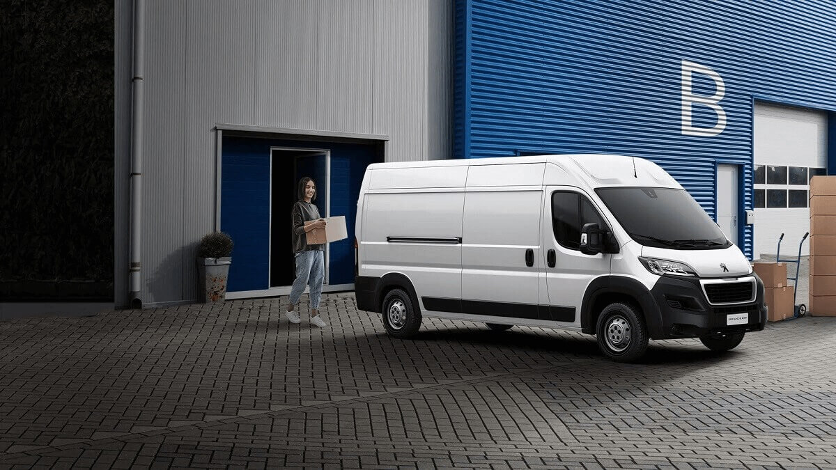 Foto de uma moça carregando um Peugeot Boxer 2023 branco