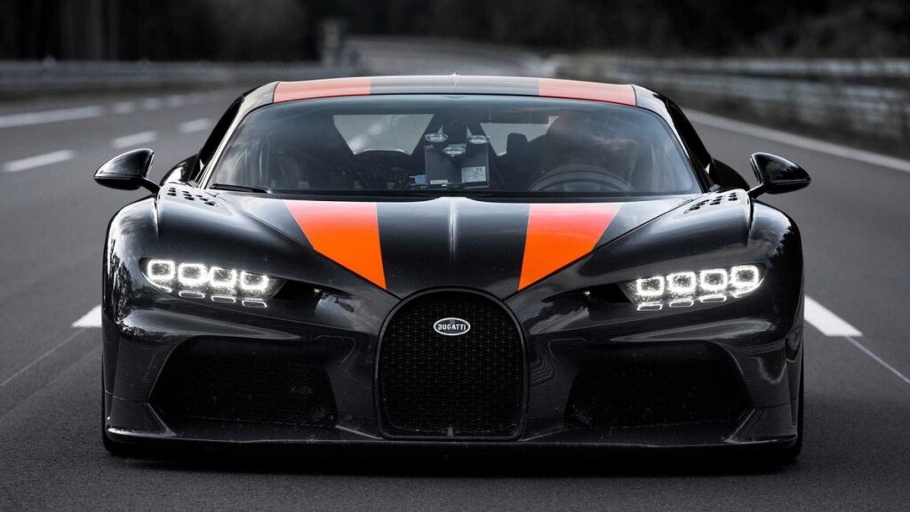 Foto frontal de um Bugatti Chiron SS 300 preto com listras laranjas sobre o capô e o teto