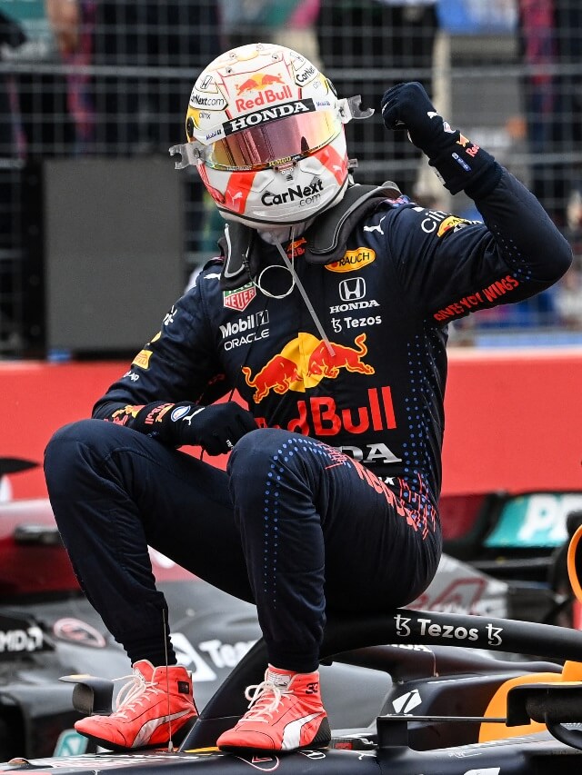 Foto do piloto Max Verstappen sentado no carro da Red Bull